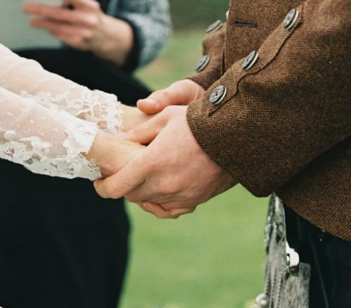 A Civil Celebrant wedding officiant holding the hands of a couple during a custom wedding ceremony.
