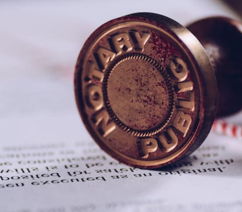 A brass Notary Public stamp for document authentication and notary services.